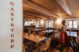 a woman standing in a restaurant with tables and chairs at Gasthaus Murauer in Simbach am Inn