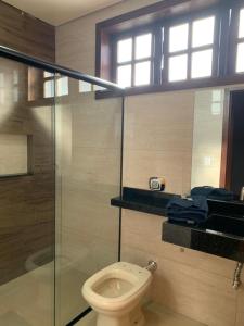 a bathroom with a toilet and a glass shower at Casa 161 in Diamantina +30 photos