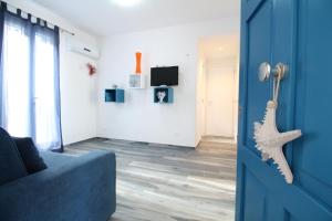 une porte bleue menant à un salon avec un canapé bleu dans l'établissement Appartamenti LE TRE ISOLE Perla e Gila, à San Vito Lo Capo