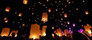 a group of people flying paper lanterns in the sky at Hôtel du Clos Fleuri in Lourdes
