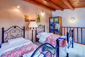 a bedroom with two beds and a lamp at Elounda Almond Tree Villa Private Pool, Sea Views & Birds in a Relaxing Authentic Cretan Escape in Vrouchas