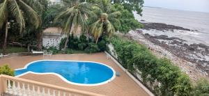 a swimming pool on a balcony next to the beach at Kiki bay in Conakry +4 photos