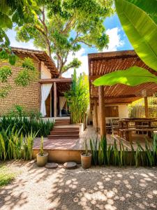 a house with a wooden porch and a patio at Pousada Awêry Caraíva in Caraíva