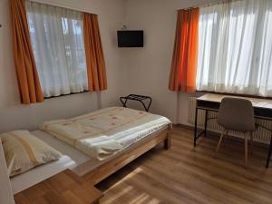 a bedroom with a bed and a desk and window at Garni Molinazzo in Agno