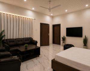 a bedroom with a bed and a couch and a tv at Vibhor peace cottage in Chitrakoot