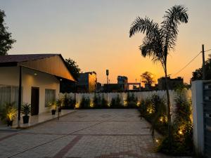 an empty driveway with a palm tree and a building at Vibhor peace cottage in Chitrakoot