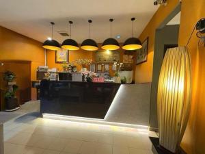 a bar in a restaurant with yellow walls and lights at Weng Kong Hotel in Slim River
