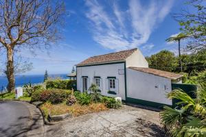 a small white house on the side of a road at GuestReady - Casa do Horizonte in Mosteiros