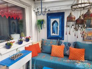 a porch with a blue couch and orange pillows at Casa Peace in Mysen