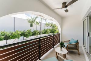a room with a balcony with palm trees at Casa Coral - Boca Poolside Escape in Boca Raton