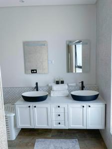 a bathroom with two sinks and a mirror at Suite 10 in Windhoek