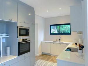 a large kitchen with white cabinets and a window at Suite 10 in Windhoek