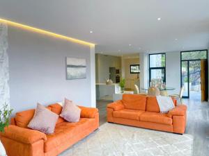 two orange couches sitting in a living room at Suite 10 in Windhoek
