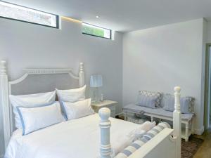 a bedroom with a white bed with white pillows at Suite 10 in Windhoek