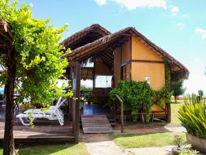 a small house with a deck and chairs in the yard at Vila Riomar in Luis Correia
