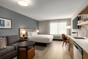 a hotel room with a bed and a couch at Hyatt Studios Harrisonburg in Harrisonburg