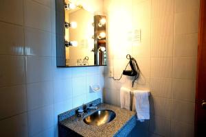 a bathroom with a sink and a mirror at Hotel Melipal in San Carlos de Bariloche +107 photos