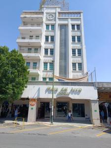 a tall white building with people walking in front of it at Hotel Plaza del Arco Express in Monterrey +39 photos