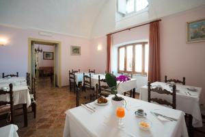 a dining room with tables and chairs with white table cloth at Pensione Di Lustro in Forio d'Ischia