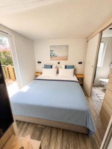 a bedroom with a large bed in a room at Mobil Home - 3CH - 2 SDB - Clim - Wifi in Roquebrune-sur-Argens
