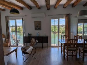 a living room with a table and chairs and windows at River Ebro Apartments in Móra d'Ebre