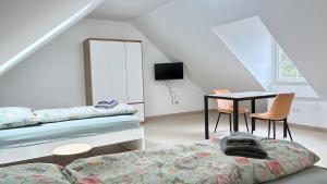 a bedroom with a bed and a table and chairs at Atelier überm Hof in Alzenau