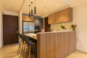 a kitchen with a counter and a bar with stools at SOLARIS APARTMENT-Sky Suites in Accra