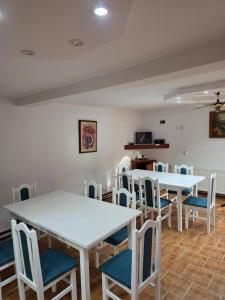 a room with white tables and blue chairs at Happy Family in Suceviţa