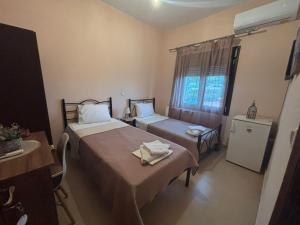 a hotel room with two beds and a window at Catherine Seaside Apartment in Ouranoupoli