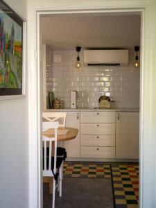 a kitchen with white cabinets and a table at Stenkullens gårdshus in Borensberg