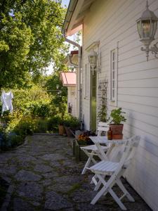 a patio with two white chairs on the side of a house at Stenkullens gårdshus in Borensberg