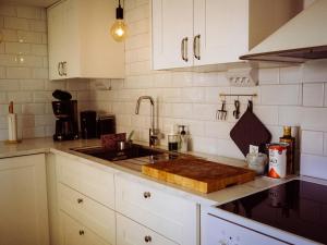 a kitchen with a wooden cutting board on a counter at Stenkullens gårdshus in Borensberg +29 photos
