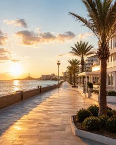 a sidewalk next to the ocean with palm trees at Milano by Alina365 in La Manga del Mar Menor