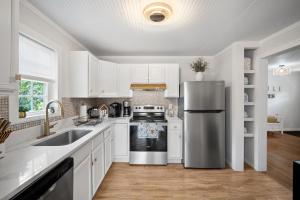 a kitchen with white cabinets and a stainless steel refrigerator at Little Elves Overlook in Sparta