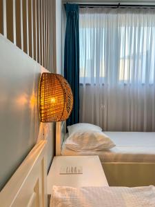 a room with two beds and a lamp and a window at La Cupric in Sarichioi