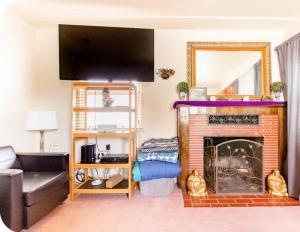 a living room with a fireplace with a flat screen tv at Sacred Heart House in Montebello