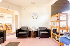 a living room with two chairs and a table at Sacred Heart House in Montebello