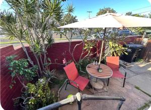 a patio with a table and chairs and an umbrella at Sacred Heart House in Montebello