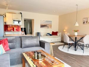 a living room with a couch and a table at Wahlheimat Haffkrug, Strandnaher Ostseeurlaub, Terrasse, Tiefgarage und WLAN in Scharbeutz