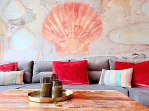 a room with a couch and a table with red pillows at Wahlheimat Haffkrug, Strandnaher Ostseeurlaub, Terrasse, Tiefgarage und WLAN in Scharbeutz