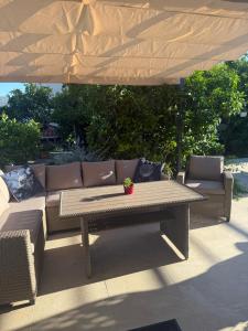 a couch and a table under a large umbrella at Blue Sunset in Razvala