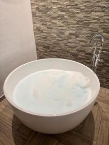 a white bath tub sitting on top of a wooden floor at CUEVAS del PEÑÓN in Grazalema