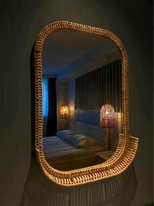 a bedroom with a large wicker mirror on the wall at La Cupric in Sarichioi +35 photos