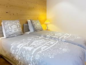 a bedroom with a bed with a white blanket and pillows at Snow Rabbit Lodge in Chamonix