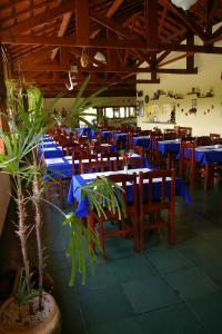 ein Restaurant mit blauen Tischen und Stühlen und Pflanzen in der Unterkunft Pousada e Marina Pier 44 in Nazaré Paulista