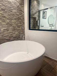 a white bath tub in a bathroom with a window at CUEVAS del PEÑÓN in Grazalema