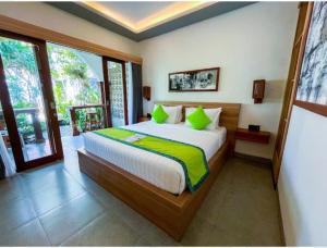 a bedroom with a large bed with green pillows at Green Bali Guest House in Munggu +26 photos