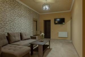 a living room with a couch and a table at Old House Residence Aghveran & Restaurant in Arzakan