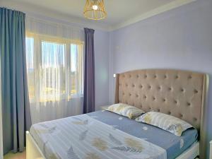 a bed in a bedroom with a window and a mattress at Wide Beach Apartments 236 in Mullini i Danit