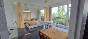 a bedroom with two beds and a balcony at Mist Farm Resort in Avanāshi